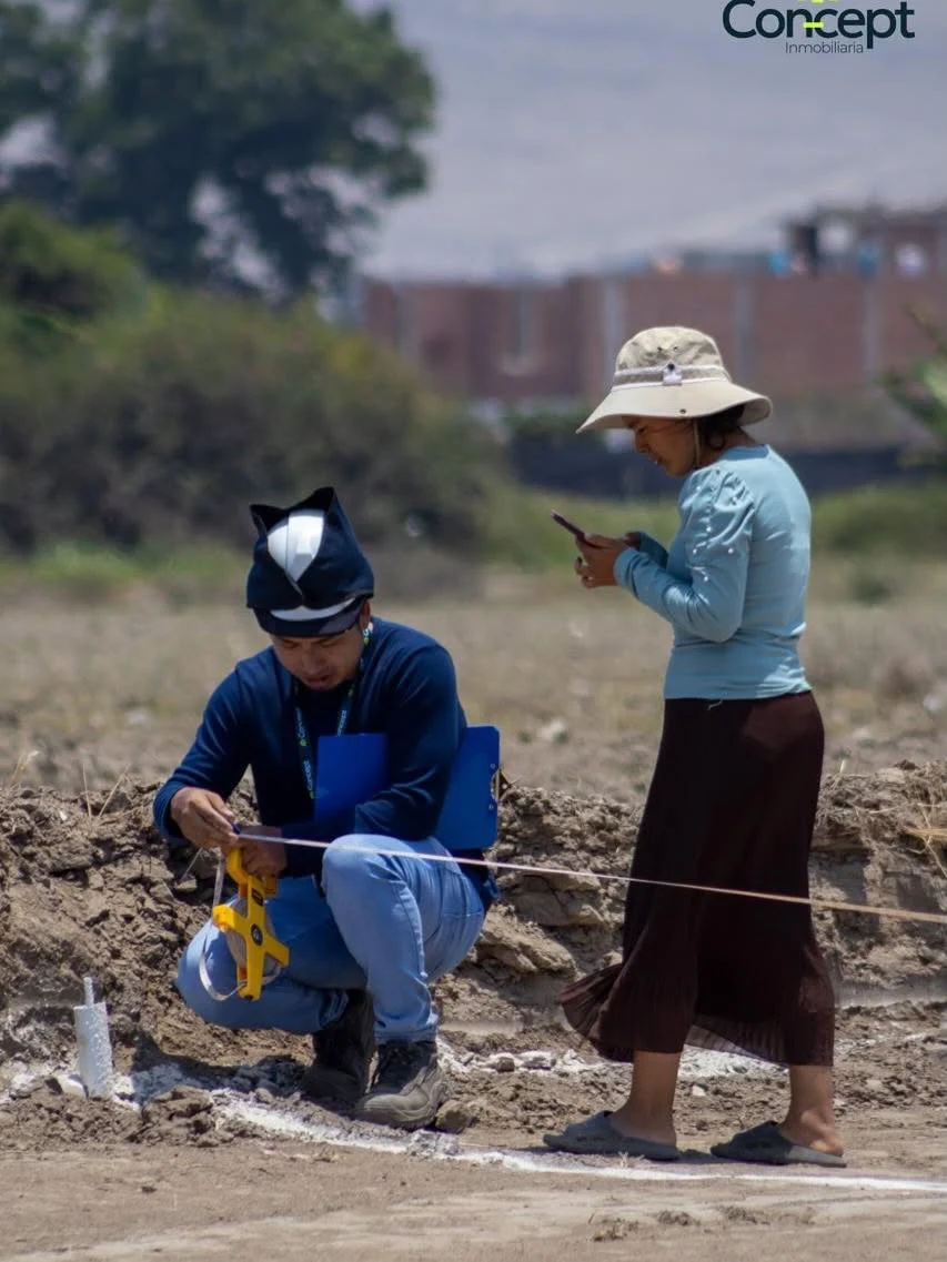 Equipo técnico verificando las medidas de un lote en el terreno